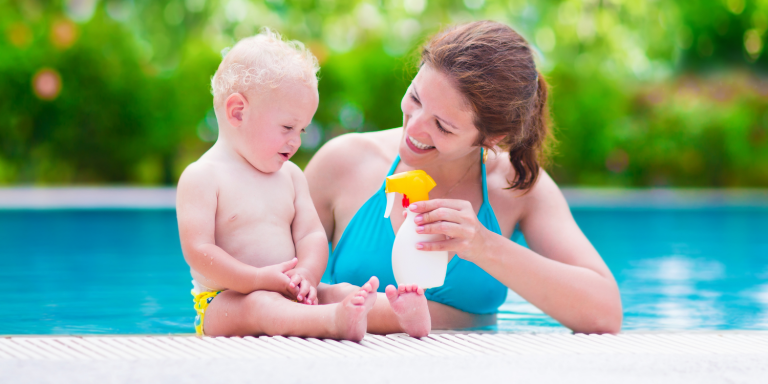 a mother applying sunscreen to her baby